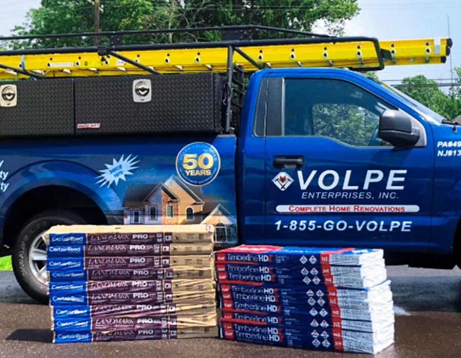 A Volpe Enterprises truck arrives at a home with roofing materials.