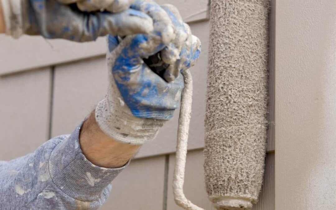 Should You Paint Your Siding? A Man Paints His Siding with a roller.